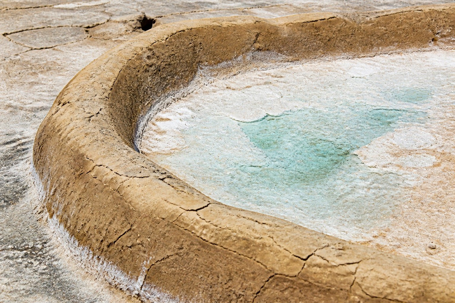 Clay basin rim of an evaporation pan with white crystal crust